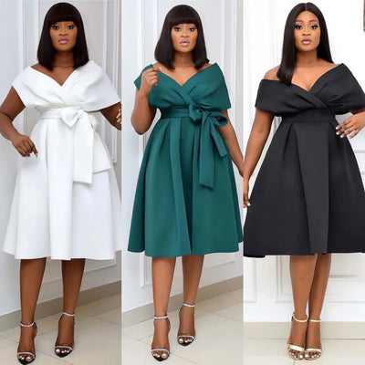 Trois femmes portant des robes élégantes avec ceinture, en blanc, vert et noir, posent dans un intérieur moderne. Mode féminine chic et tendance.