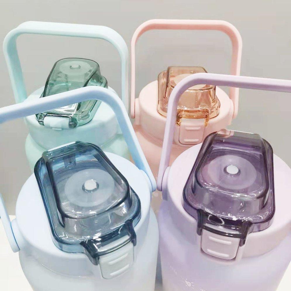 Quatre bouteilles d'eau en plastique colorées avec poignées et couvercles transparents. Design moderne, idéal pour hydratation quotidienne.