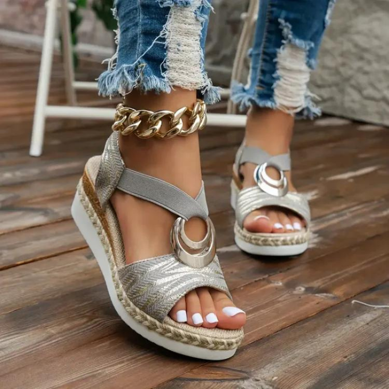Sandales compensées argentées avec boucle dorée, portées avec un jean déchiré. Chaussures d'été tendance pour femmes, mode décontractée chic.