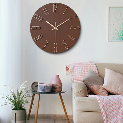 Horloge murale marron moderne avec chiffres dorés, accrochée dans un salon élégant avec canapé beige, coussins et table d'appoint en bois.