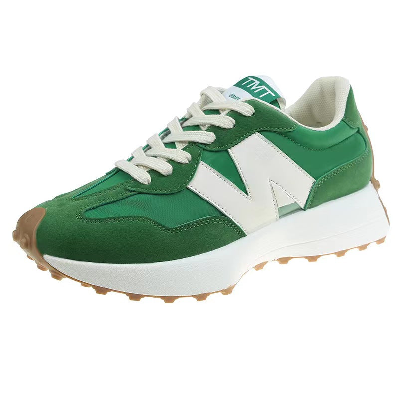 Chaussure de sport verte et blanche avec semelle épaisse, lacets blancs et logo en forme de "N". Design moderne et confortable pour la course.