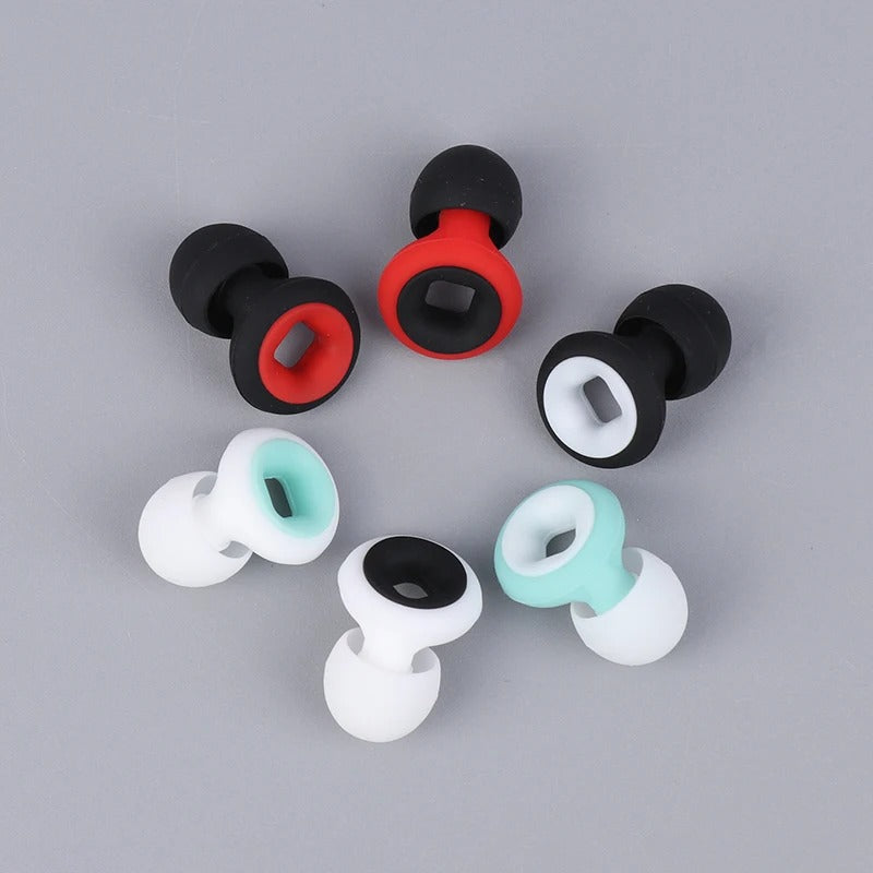 Boucles d'oreilles tunnel en silicone multicolores, noir, rouge, blanc, turquoise, sur fond gris. Accessoires de mode, piercing, style moderne.