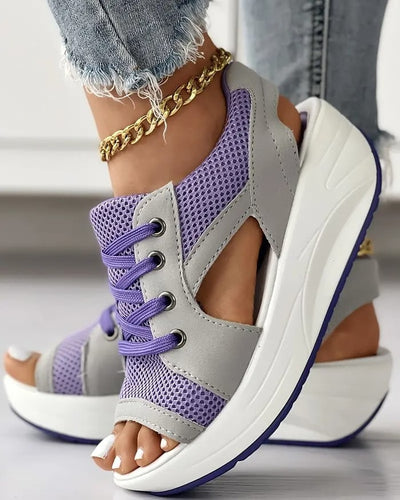 Sandales compensées violettes et grises avec lacets, portées avec un jean déchiré et bracelet doré. Chaussures tendance, mode été femme.