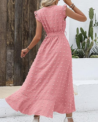 Robe longue rose à pois, manches à volants, ceinture à la taille, femme de dos, cactus en arrière-plan, style estival décontracté.