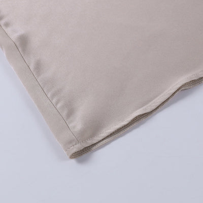 Coin d'une taie d'oreiller en satin beige, texture lisse et brillante, idéale pour soins capillaires et peau, luxe et confort pour chambre à coucher.