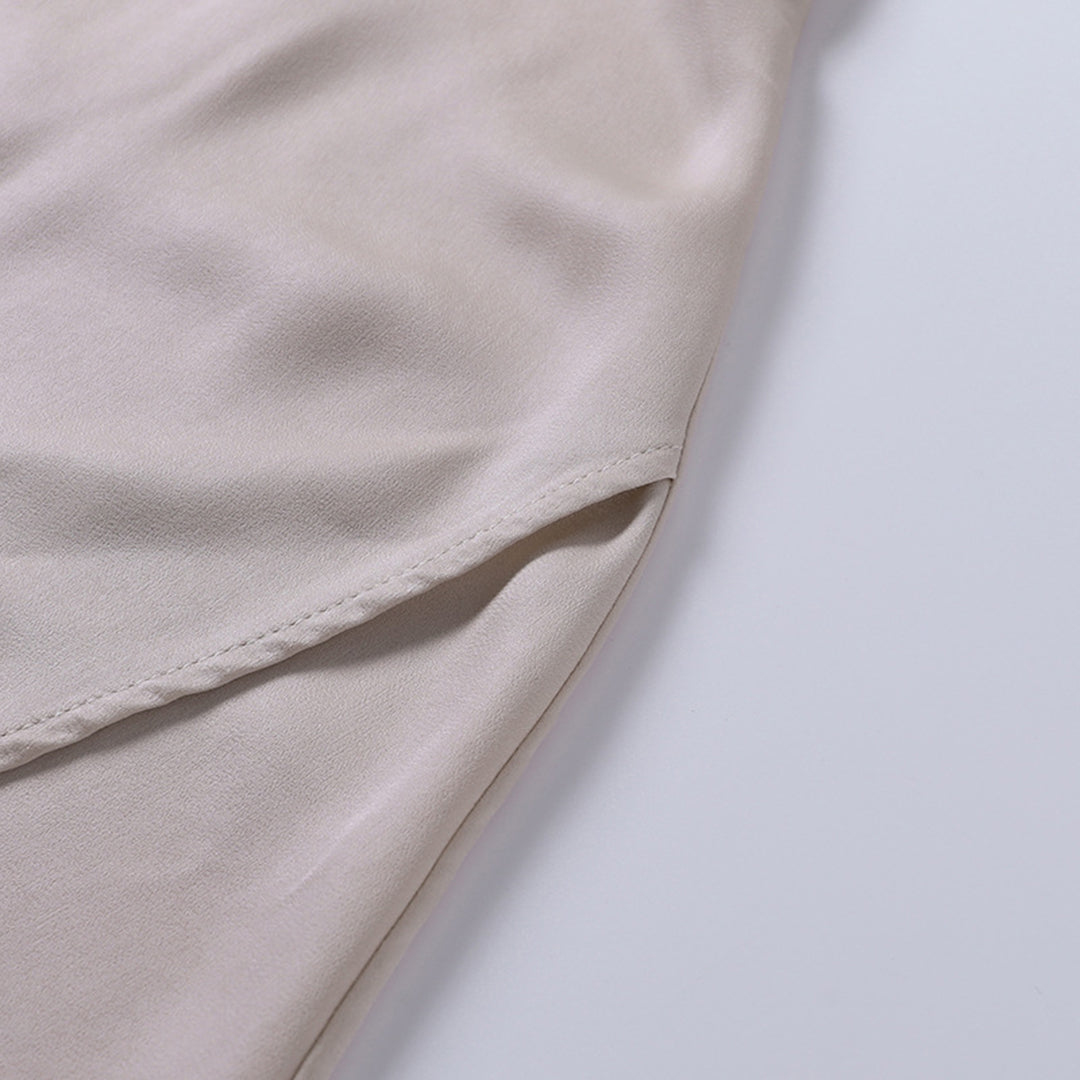 Manche de chemise en satin beige, tissu doux et élégant, gros plan sur la couture, mode féminine, vêtement chic et tendance.
