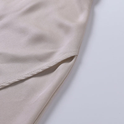 Manche de chemise en satin beige, tissu doux et élégant, gros plan sur la couture, mode féminine, vêtement chic et tendance.