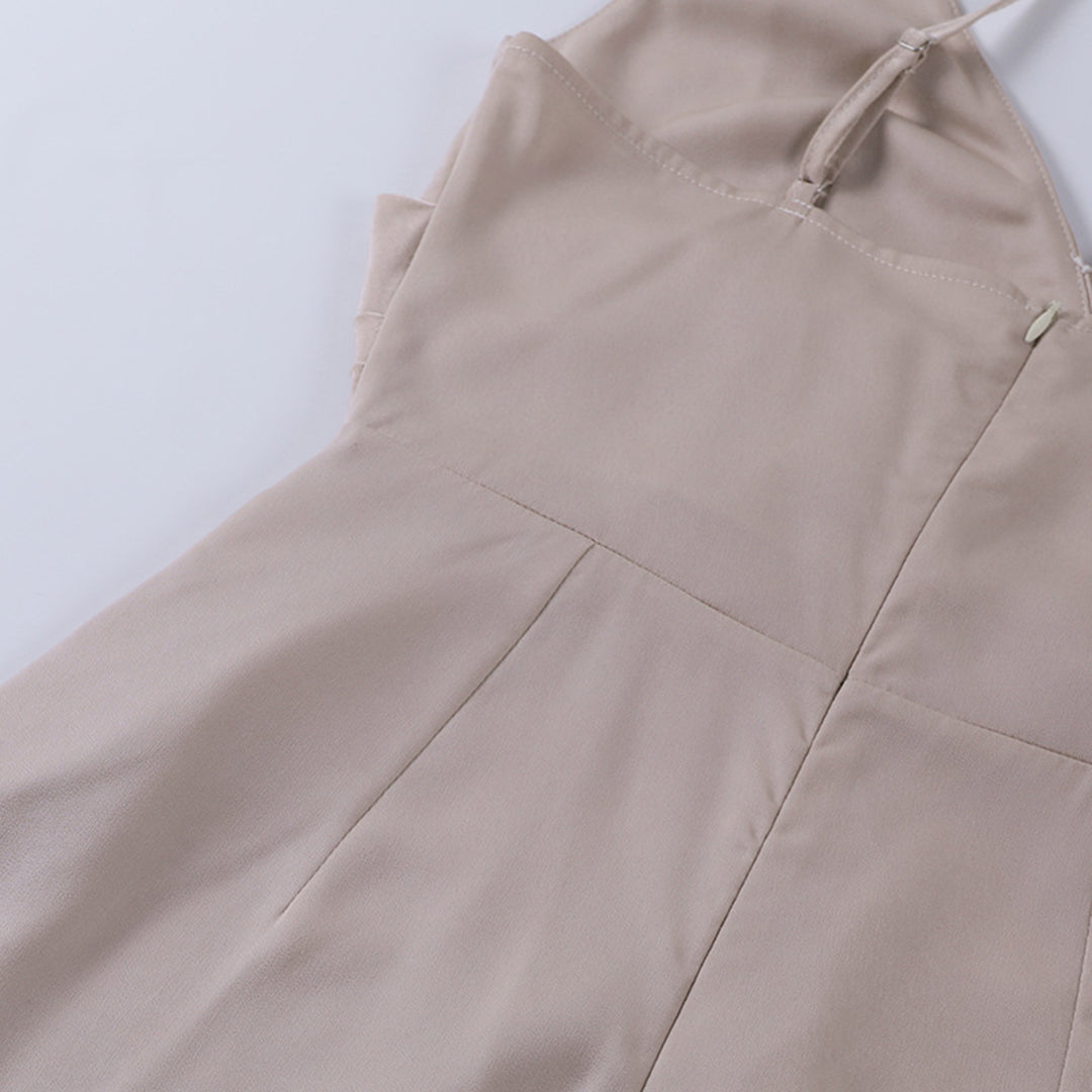 Robe beige élégante en tissu doux, avec bretelles fines et couture précise, posée à plat sur fond blanc. Mode féminine, tenue chic.