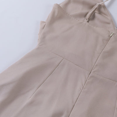 Robe beige élégante en tissu doux, avec bretelles fines et couture précise, posée à plat sur fond blanc. Mode féminine, tenue chic.