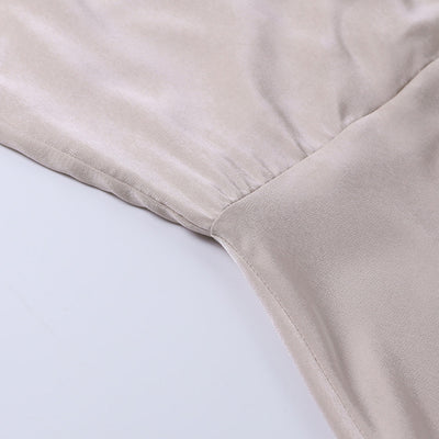 Robe en satin beige, tissu doux et brillant, couture élégante, mode féminine, vêtement chic, style luxueux, détail de couture raffinée.