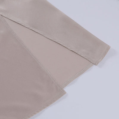 Manche de chemisier en satin beige, tissu doux et brillant, gros plan. Mode élégante, vêtement féminin, texture soyeuse, tendance actuelle.