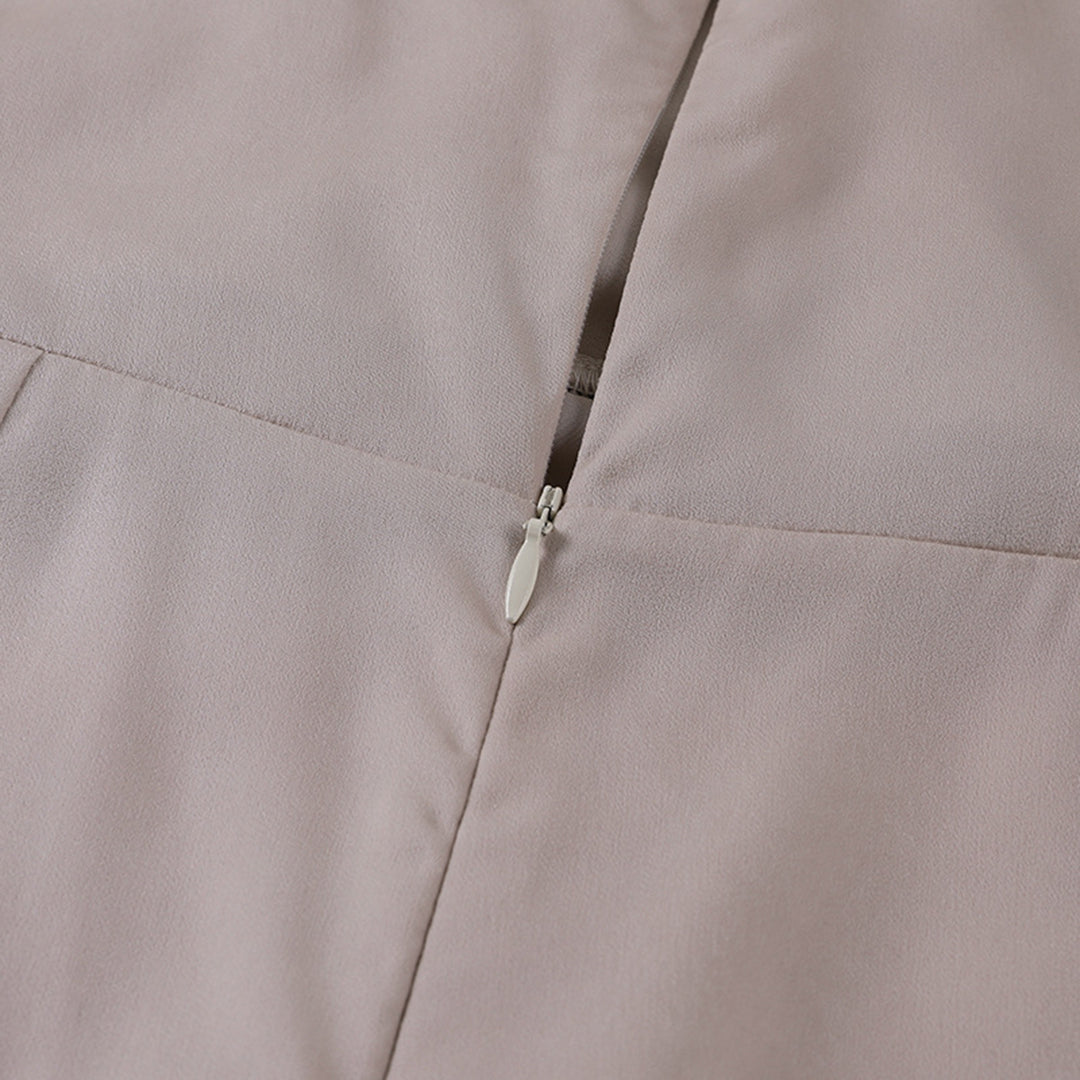 Fermeture éclair sur tissu beige, gros plan. Mode, couture, textile élégant, détail de vêtement, design minimaliste.