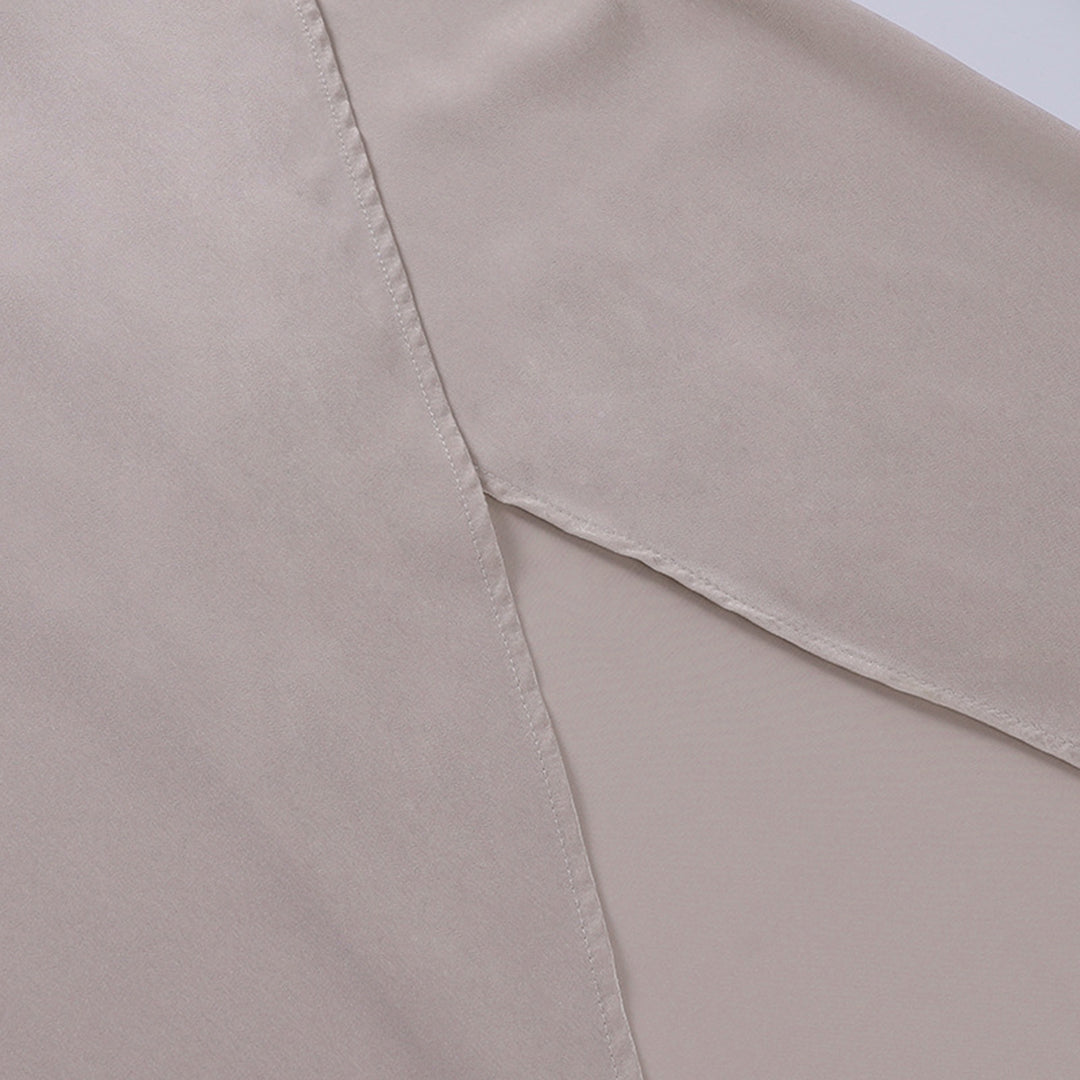Chemisier en satin beige, tissu doux et soyeux, couture visible, mode élégante, vêtement féminin, texture lisse, style chic et moderne.