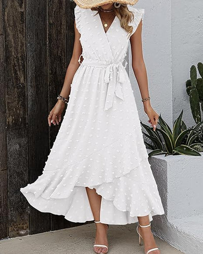 Robe blanche élégante à pois, sans manches, avec ceinture nouée, portée par une femme. Style chic et estival, idéal pour les occasions spéciales.