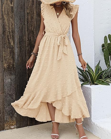 Robe longue beige à volants et pois, ceinture nouée à la taille, portée par une femme. Style élégant et estival, parfait pour les occasions décontractées.