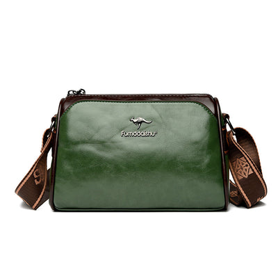 Sac à bandoulière en cuir vert et marron avec logo, design élégant et moderne, idéal pour la mode féminine. Accessoire tendance et pratique.
