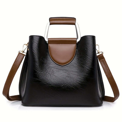 Sac à main en cuir noir et marron avec bandoulière réglable, design moderne, poignée métallique, mode femme, accessoire élégant.