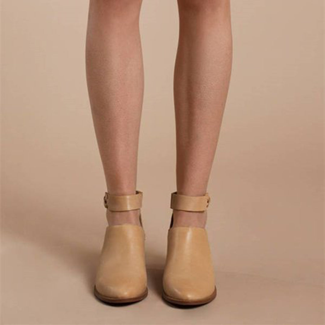 Chaussures beiges en cuir avec bride cheville, portées par une personne sur fond beige. Mode féminine, tendance chaussures automne.