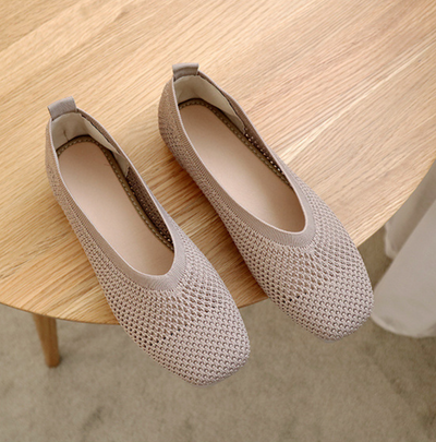 Ballerines beiges en maille sur table en bois, chaussures confortables et élégantes pour femmes, design moderne et respirant.