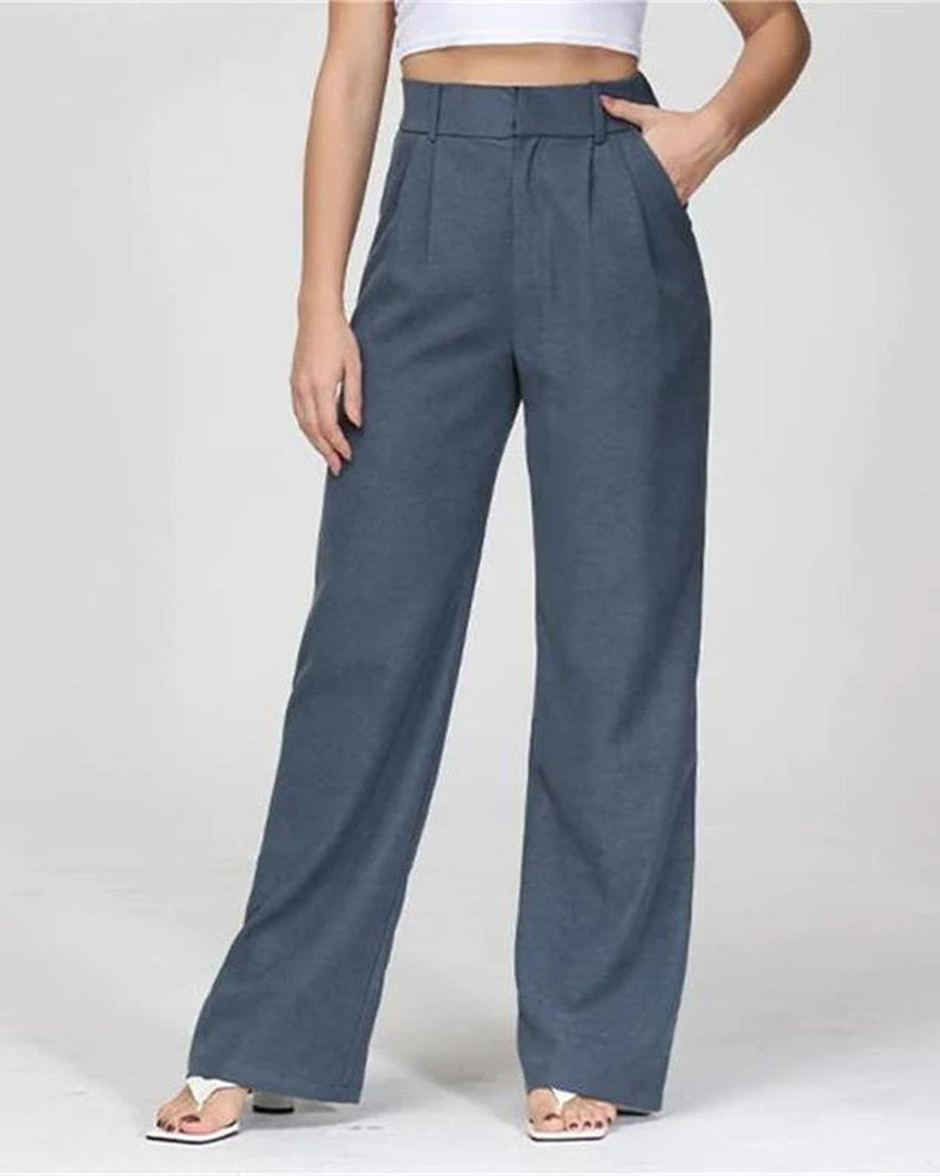 Pantalon large bleu taille haute pour femme, style décontracté, avec poches, porté avec un haut blanc. Mode féminine élégante et moderne.
