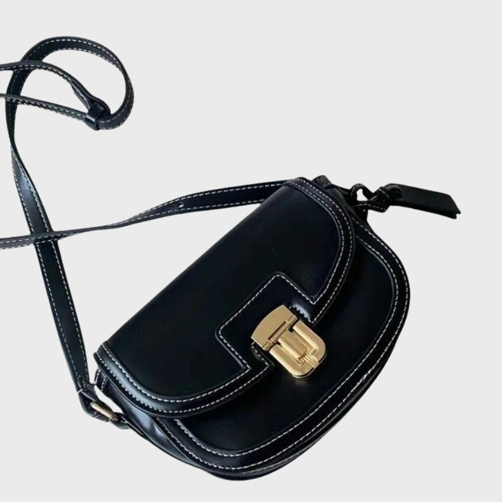 Sac à bandoulière en cuir noir avec surpiqûres blanches et fermoir doré. Accessoire mode élégant pour femme, tendance et chic.
