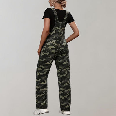 Femme portant une salopette camouflage verte, t-shirt noir et baskets blanches, vue de dos. Mode décontractée, tendance militaire.