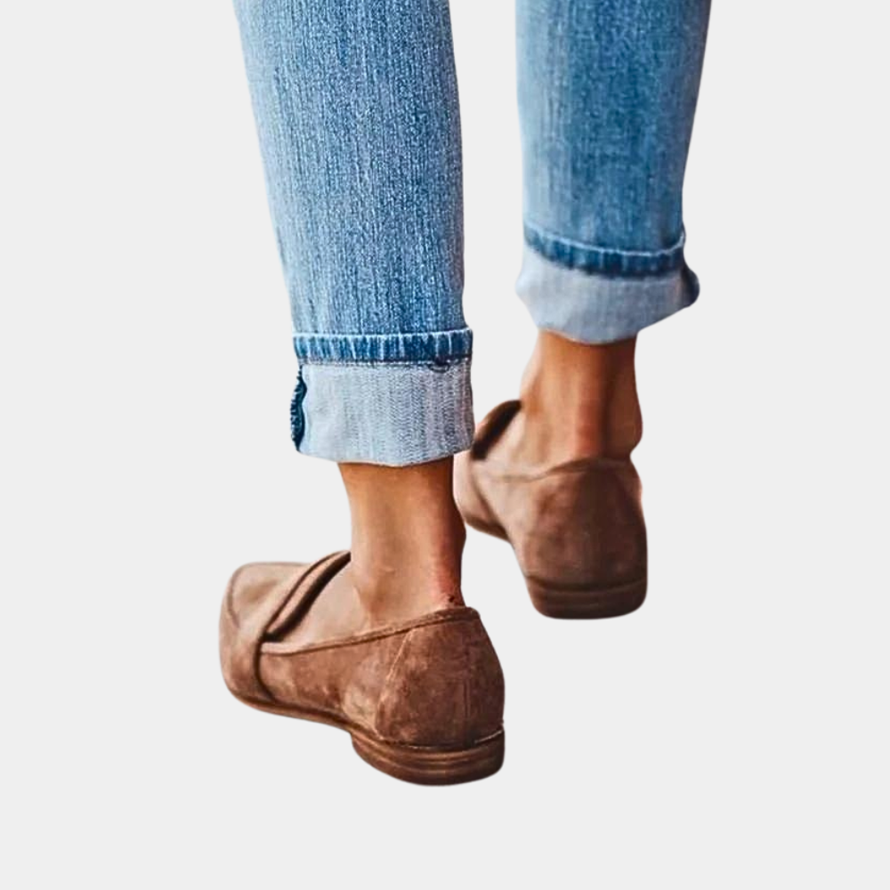 Jeans bleus retroussés avec mocassins marron en daim, mode décontractée, vue arrière, style urbain, chaussures confortables pour femme.