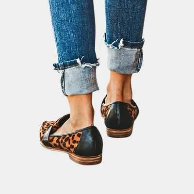 Jeans retroussés avec mocassins léopard et cuir noir, mode décontractée femme, chaussures tendance, style urbain chic.