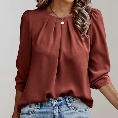 Blouse élégante en satin marron avec manches longues et plis, portée avec un jean décontracté. Mode féminine chic et tendance automne.