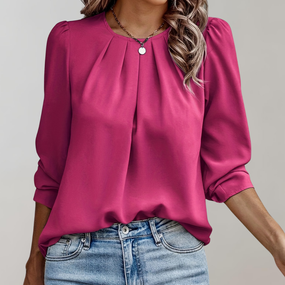 Blouse rose fuchsia à manches longues, col rond plissé, portée avec un jean bleu. Mode féminine élégante, tendance automne, style décontracté.