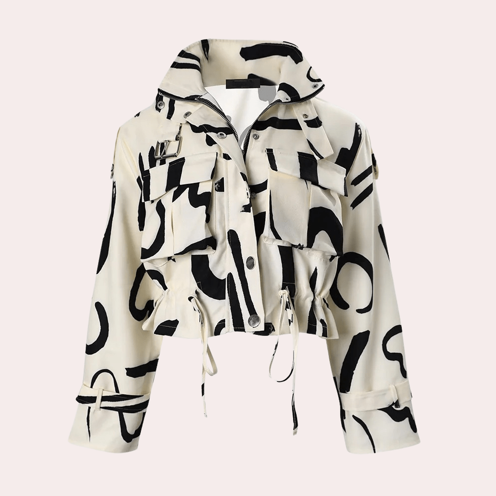 Veste courte à motifs abstraits noirs sur fond blanc, avec poches à rabat et cordons de serrage. Style moderne et tendance pour femme.