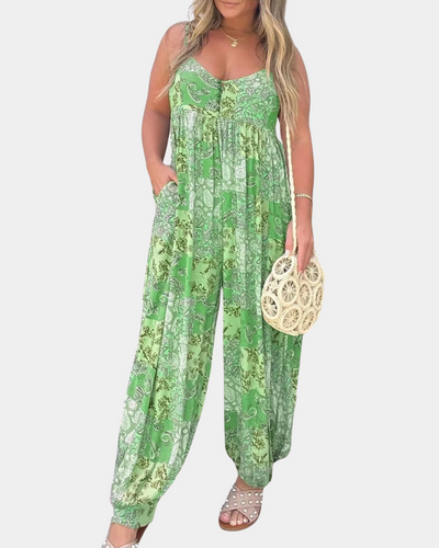 Femme portant une combinaison verte à motifs floraux, tenant un sac en osier rond. Mode estivale, tenue décontractée, style bohème chic.
