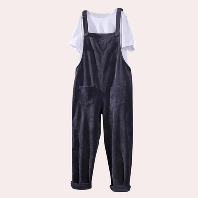 Salopette en velours côtelé noir avec poches avant, portée sur un t-shirt blanc. Mode décontractée, tendance automne-hiver, style urbain chic.