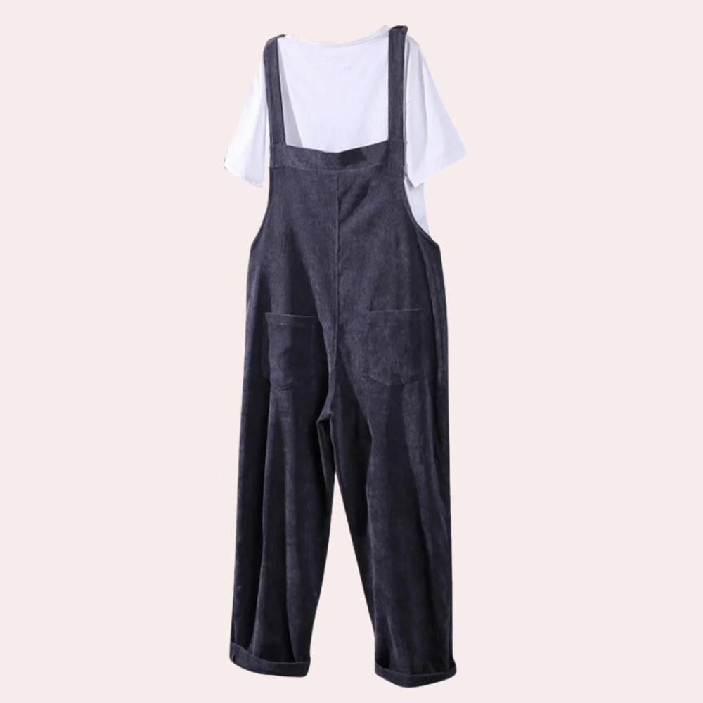 Salopette en velours côtelé gris foncé avec poches, portée sur un t-shirt blanc. Mode décontractée, tendance automne-hiver, style vintage.