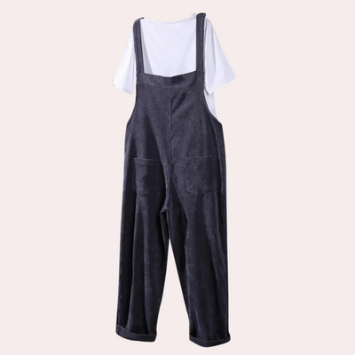 Salopette en velours côtelé gris foncé avec poches, portée sur un t-shirt blanc. Mode décontractée, tendance automne-hiver, style vintage.