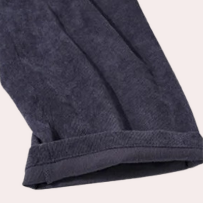 Pantalon en velours côtelé bleu marine, ourlet retroussé, tissu texturé, mode automne-hiver, vêtement élégant et confortable pour homme.