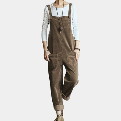 Salopette marron en velours côtelé pour femme, portée avec un t-shirt blanc à manches longues. Mode décontractée, tendance automne-hiver.