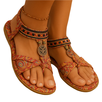 Sandales bohèmes colorées avec motifs ethniques, ornées de perles et pendentifs, portées sur pieds bronzés. Mode été, style décontracté.