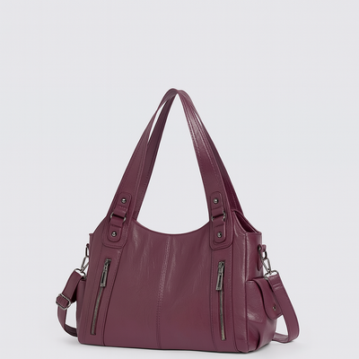 Sac à main en cuir violet avec bandoulière réglable, poches zippées et finitions métalliques. Accessoire mode élégant pour femme.