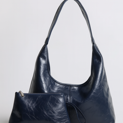 Sac à main en cuir bleu foncé avec pochette assortie, design élégant et moderne, parfait pour la mode féminine et les accessoires tendance.