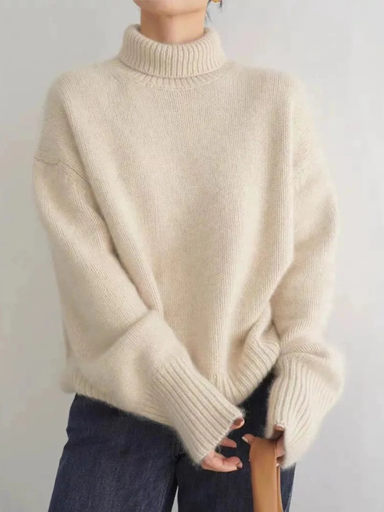 Pull en laine beige à col roulé, manches longues, porté avec un jean bleu. Mode automne-hiver, style décontracté et confortable.