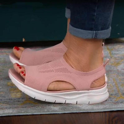 Sandales roses confortables avec semelle épaisse blanche, portées avec un jean. Chaussures d'été légères et respirantes pour femmes.