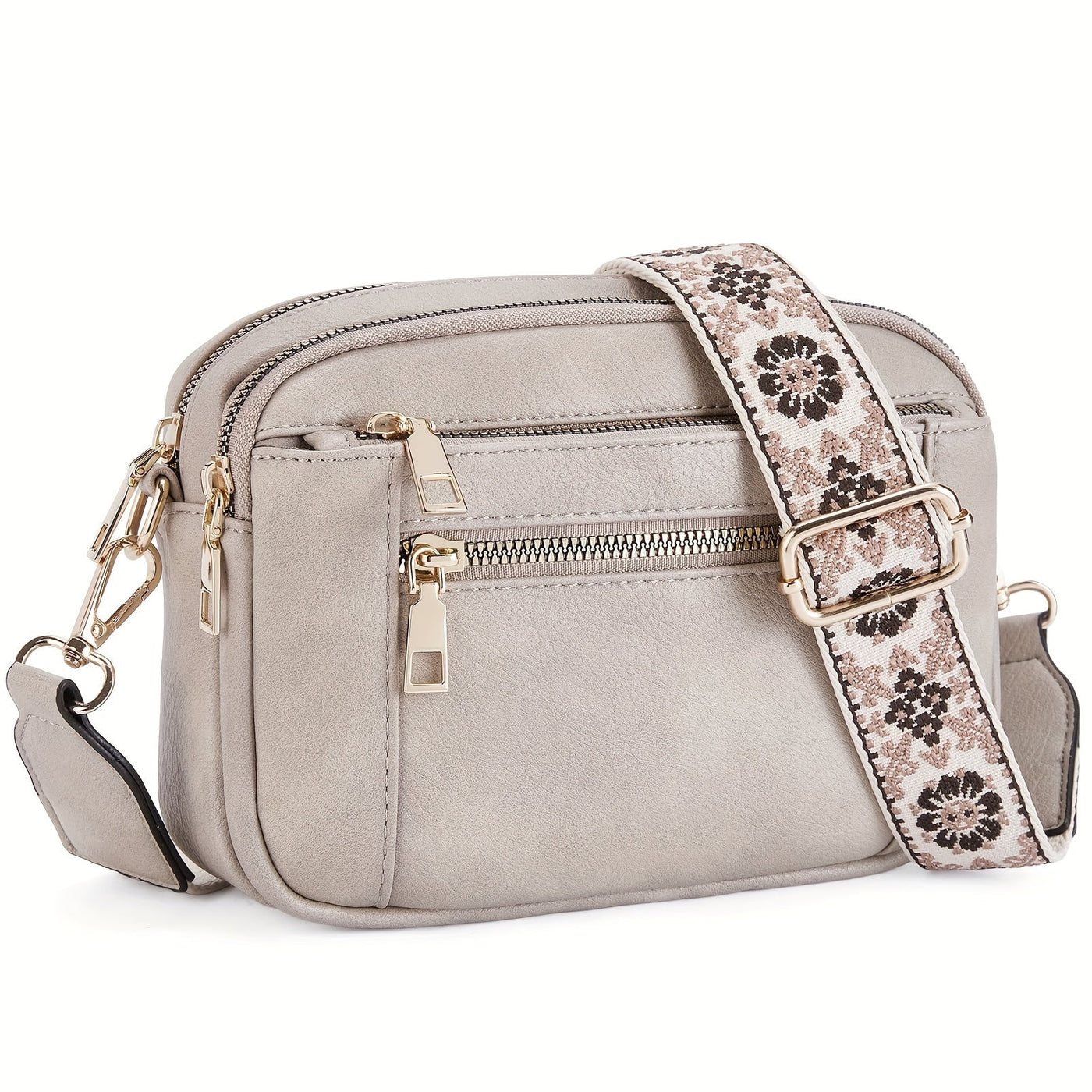 Sac à bandoulière en cuir gris avec sangle florale, fermetures éclair dorées, design élégant et moderne, idéal pour mode féminine et accessoires tendance.