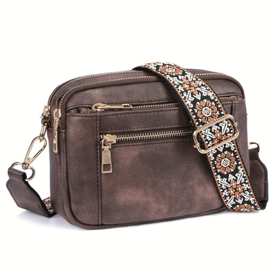 Sac à bandoulière en cuir marron avec sangle brodée ethnique, poches zippées dorées, design élégant et pratique pour femmes. Accessoire mode tendance.