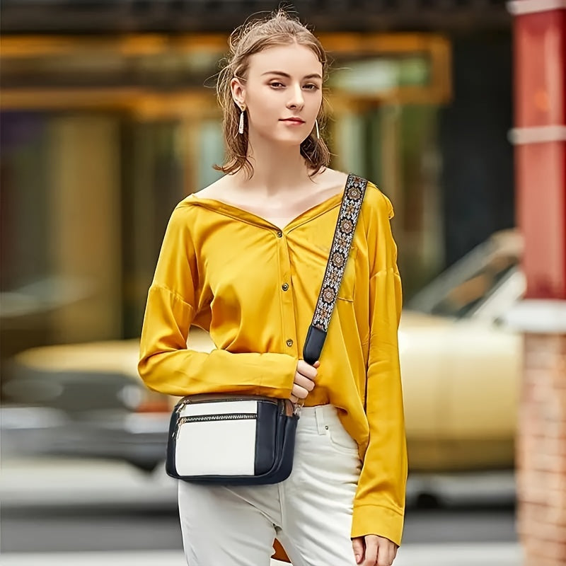 Jeune femme portant une chemise jaune et un sac à bandoulière noir et blanc, marchant en ville. Mode urbaine, style décontracté, élégance moderne.