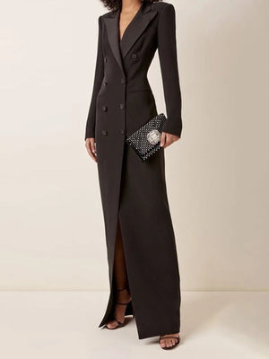 Robe longue noire élégante à double boutonnage, portée avec une pochette à motifs et des sandales à talons. Mode chic et sophistiquée pour soirée.