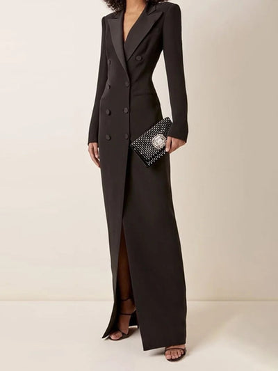 Robe longue noire élégante à double boutonnage, portée avec une pochette à motifs et des sandales à talons. Mode chic et sophistiquée pour soirée.