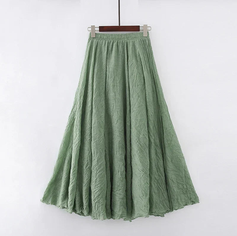 Jupe longue verte en lin, évasée, suspendue sur un cintre. Mode féminine, style bohème, tissu léger et fluide, idéale pour l'été.