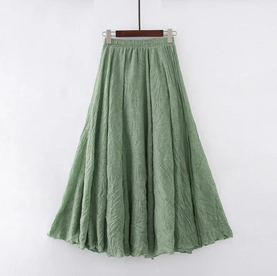 Jupe longue verte en lin, évasée, suspendue sur un cintre. Mode féminine, style bohème, tissu léger et fluide, idéale pour l'été.