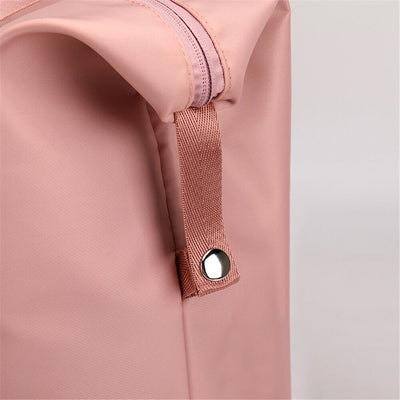 Sac à dos rose en tissu imperméable avec fermeture éclair et bouton-pression argenté, design moderne et minimaliste, idéal pour la mode urbaine.